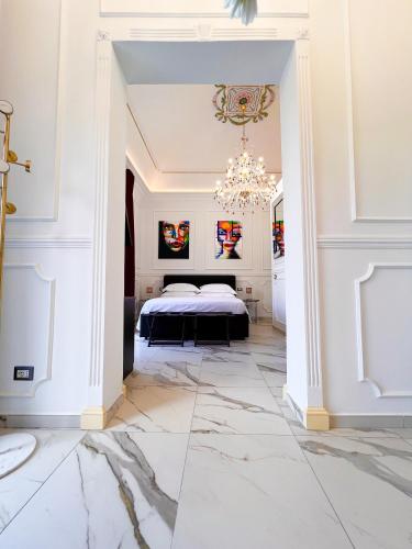 Ricci Palace Suites في كاتانيا: غرفة نوم بسرير وثريا