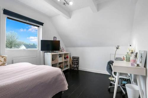 a bedroom with a bed and a desk and a window at Lejlighed/rækkehus med adgang til pool. in Vipperød