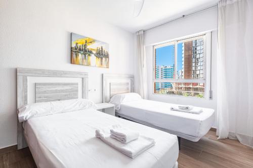 ベニドルムにあるEtxezuri I 6-D Apartment Levante Beachの白い部屋で、ベッド2台、窓が備わります。