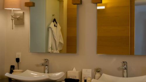 a bathroom with two sinks and two mirrors at Cartesiano Boutique & Wellness Hotel in Puebla