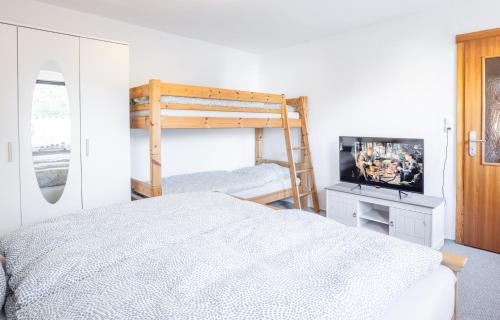Zur Kleinen Hummel في جيرنروده هارتس: غرفة نوم مع سرير بطابقين وتلفزيون