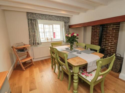 a dining room with a table and chairs and a brick wall at Inglenook Cottage in Guisborough