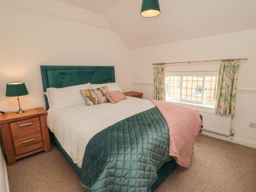 a bedroom with a large bed and a window at Inglenook Cottage in Guisborough