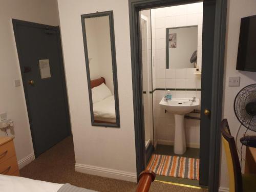 uma casa de banho com um lavatório e um espelho em Ababeel Hotel em Birmingham