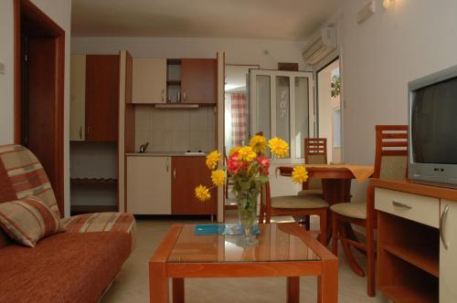 ein Wohnzimmer mit einer Blumenvase auf dem Tisch in der Unterkunft Hotel Kamelija in Tivat