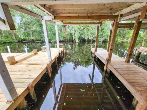 a wooden dock on a body of water at Astor River House with 2 private boat slips in Astor