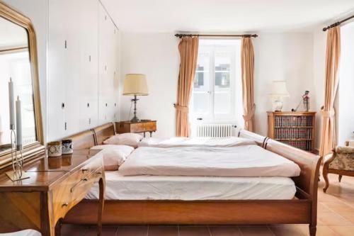 a bedroom with two beds and a table and a mirror at Chambre d'hôte au milieu des vignes avec magnifique vue sur le lac et jardin in Féchy