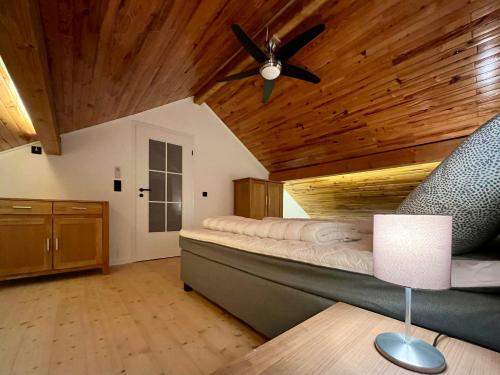 1 dormitorio con 1 cama y ventilador de techo en Blockhaus Ourtal en Winterspelt