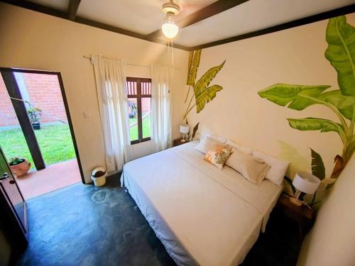 sypialnia z białym łóżkiem i dużym oknem w obiekcie Casa Tesoro Selva w mieście Tarapoto