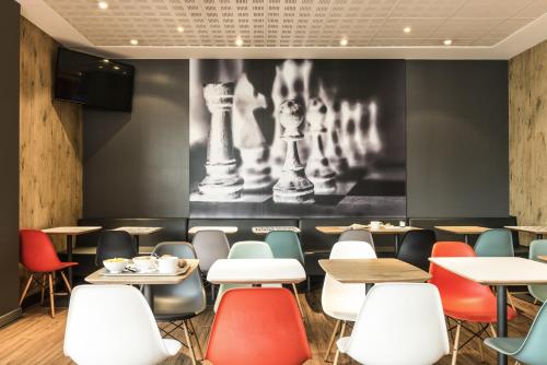 a dining room with tables and chairs and a picture of chess at ibis Bordeaux Centre Bastide in Bordeaux