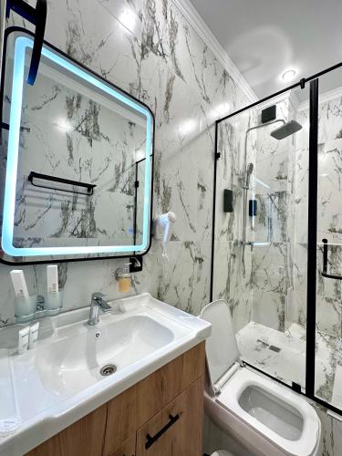 a bathroom with a sink and a shower with a mirror at Freedom hotel in Almaty