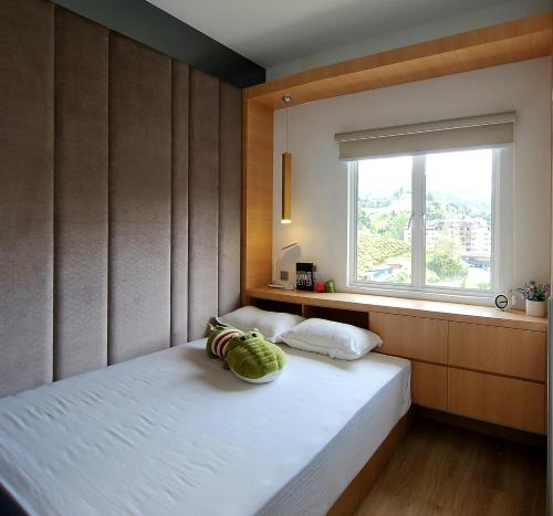 a bedroom with a large bed with a window at Peony Square Residences in Cameron Highlands
