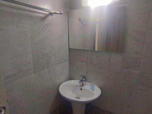 W białej łazience znajduje się umywalka i lustro. w obiekcie Στούντιο Στη Στοά Βαρβουτσή Νούμερο#7 w Kalamácie