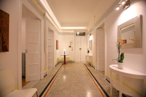 un corridoio con porte bianche e pavimento piastrellato di GUESTHOUSE GRANDI STAZIONI _ bari centro s.l._ a Bari