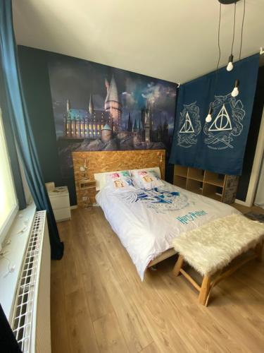 une chambre avec un lit et un tableau au mur dans l'établissement Appartement hyper centre Reims Le gîte du sorcier, à Reims
