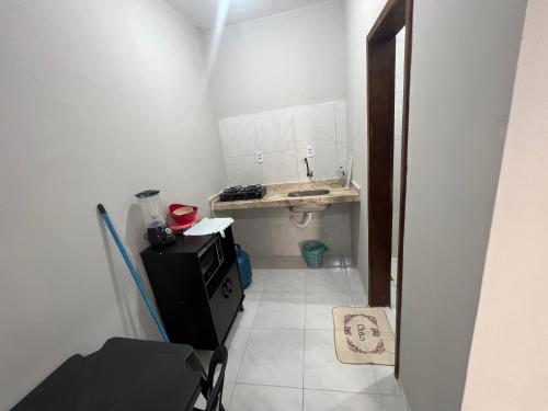 Elle comprend une petite salle de bains pourvue d'un lavabo et d'un comptoir. dans l'établissement Ap Mobiliado no Campo dos Velhos, à Sobral