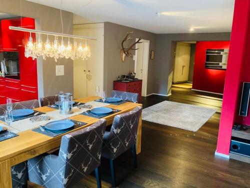 una sala da pranzo con un lungo tavolo e piatti blu di Stunning Luxury apartment in Central Klosters a Klosters