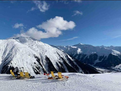 a group of chairs on top of a snow covered mountain at Stunning Luxury apartment in Central Klosters in Klosters