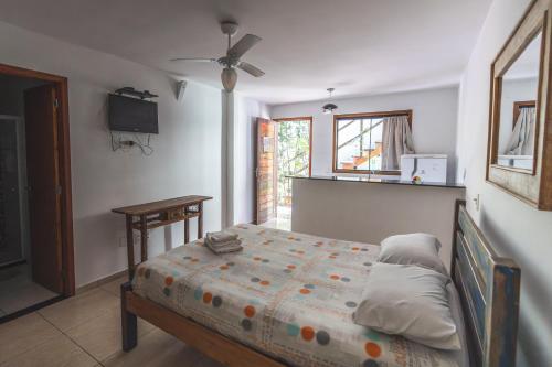 a bedroom with a bed and a table and a window at POUSADA ENCANTO DO AMOR in Búzios