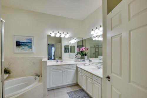 baño blanco con 2 lavabos, bañera y bañera en Spacious Palm Coast Condo Balcony, Beach Access!, en Palm Coast