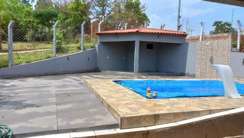 a small swimming pool in a backyard with a house at Chácara Recanto da Paz in Caldas Novas
