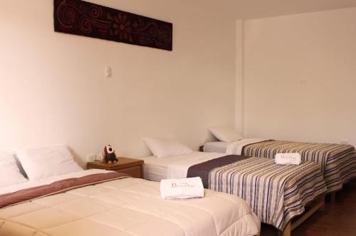 2 camas en una habitación de hotel con carteles en Ecolodge Huaca Piedra, en Illimo