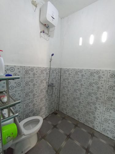 a bathroom with a toilet and a shower at The GARE'S VILLA MANDALIKA in Kuta Lombok