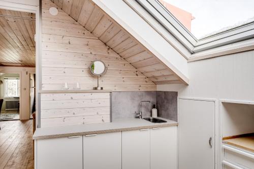 eine Küche mit weißen Schränken und einem Dachfenster in der Unterkunft Large house by lake in Tollered in Tollered