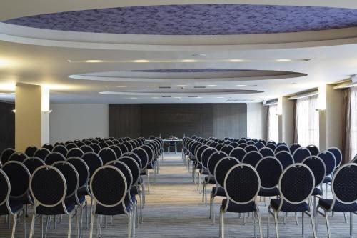 an empty room with rows of chairs and a stage at Atlantica Mikri Poli Crete in Makry Gialos