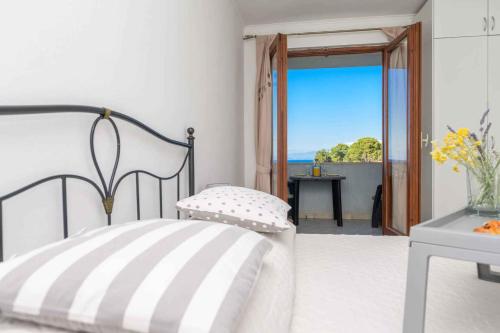 a bedroom with a bed and a view of the ocean at Apartments in Veli Losinj 26474 in Veli Lošinj