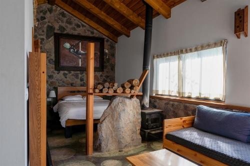 a bedroom with a bed and a tree stump in it at The green and red cabins in Ma'ale Gamla