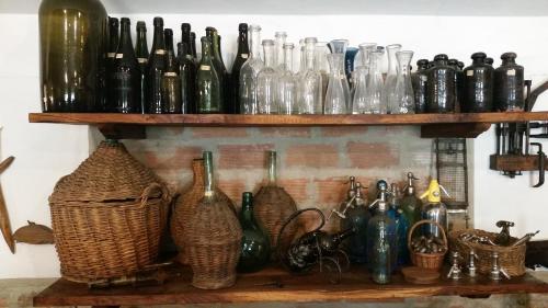 a shelf with many glass bottles and baskets on it at Casa Selene Rocchi in Savignano sul Panaro