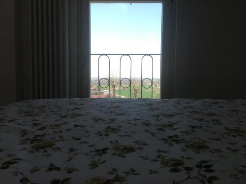 a bedroom with a bed and a large window at Casa Selene Rocchi in Savignano sul Panaro