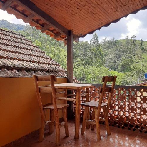 a table and two chairs on a porch with a view at Suite Maromba in Núcleo Mauá