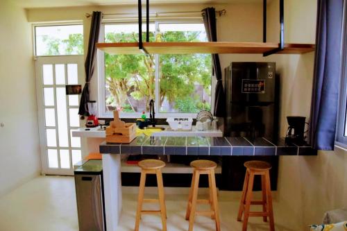 uma cozinha com um balcão com bancos e um lavatório em Mangal Suites em Brisas de Zicatela