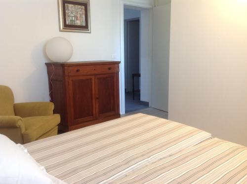a bedroom with a bed and a cabinet and a chair at Casa Selene Rocchi in Savignano sul Panaro