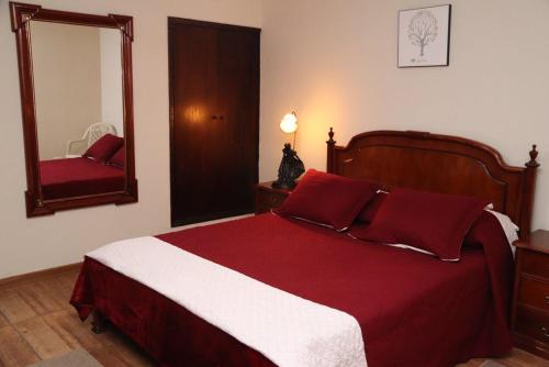a bedroom with a red and white bed and a mirror at Hotel Estância in Poços de Caldas