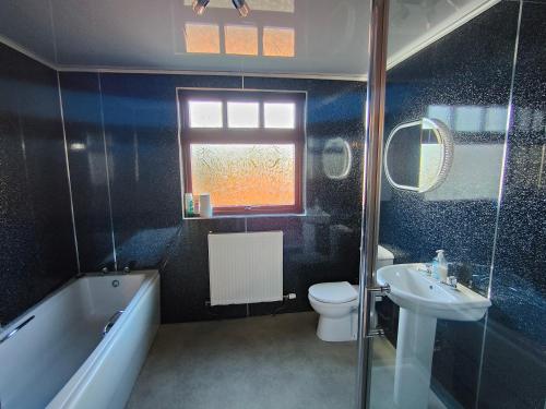 a bathroom with a tub toilet and a sink at The Mill Lade - Hidden House in Arbroath