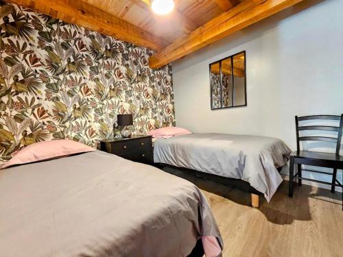 1 dormitorio con 2 camas y un mural en la pared en Le Cottage du Château, 