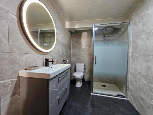 ein Badezimmer mit einem WC, einem Waschbecken und einem Spiegel in der Unterkunft Le Cottage du Château 