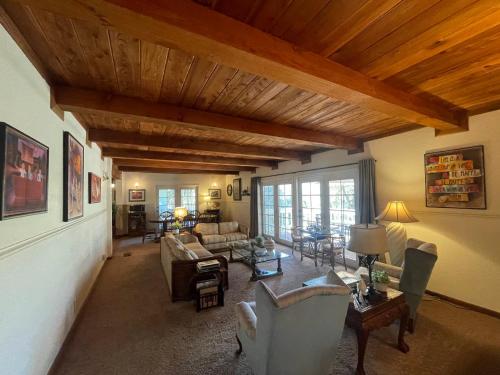 un soggiorno con divani, sedie e soffitto in legno di Berkshire Inn a Groveland