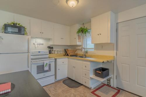 La cuisine est équipée de placards blancs et d'un réfrigérateur blanc. dans l'établissement Executive Apartment in Fairbanks, à Fairbanks