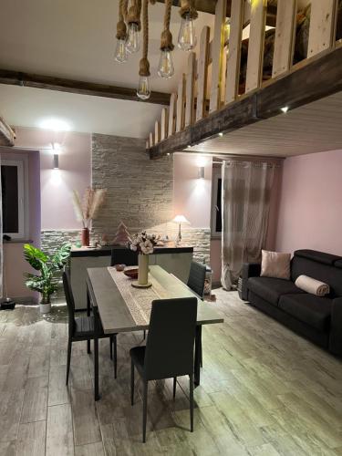 uma sala de estar com uma mesa e cadeiras e um sofá em Nilù near Rome,Nettuno em Nettuno