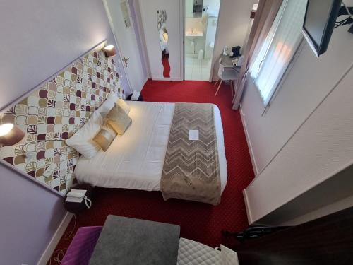 a view of a bedroom with a bed in a room at Cit'Hotel Les Atlantes in Médis