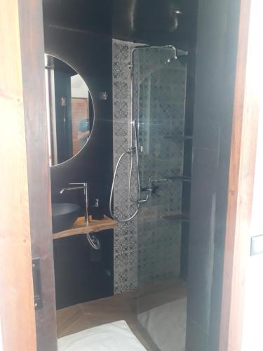 a bathroom with a shower with a sink and a mirror at Dar Khedija in El Kheriba