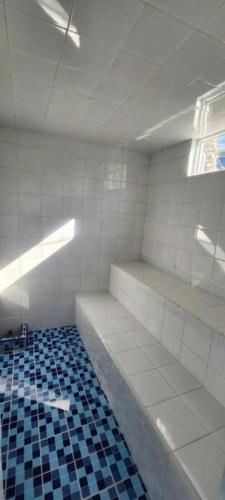 an empty room with white walls and blue tiles at Apartasol Ciudadela Santafe in Santa Fe de Antioquia