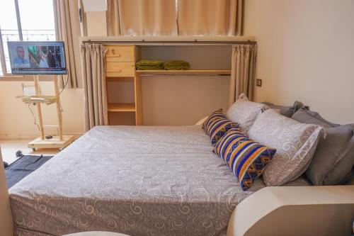 a bedroom with a bed with pillows on it at SurfAppart Morocco in Tamraght Ouzdar