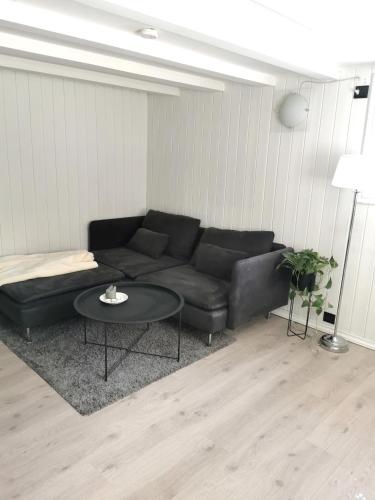 a living room with a black couch and a table at Cozy apartment near city centre in Stavanger