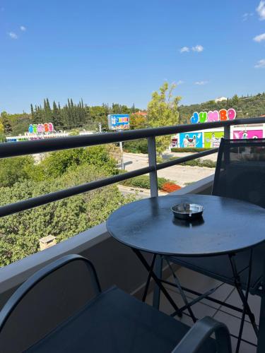 a table and chairs on a balcony with a view of a playground at Peania Domus in Paianía