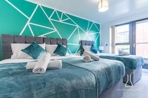 a bedroom with two large beds with blue walls at Luxury Birmingham City Centre Townhouse with BALCONY- Sleeps 10 - FREE Parking - Perfect for Contractors, Business Travellers, Families and other Groups - Near Bullring, Newstreet, Selfridges, NEC, NIA & Birmingham airport in Birmingham